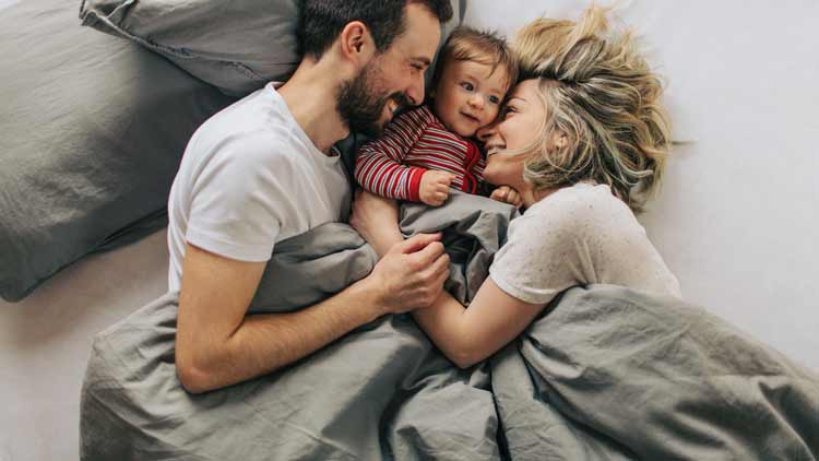 Ein Mann und eine Frau mit ihrem Kind im Bett